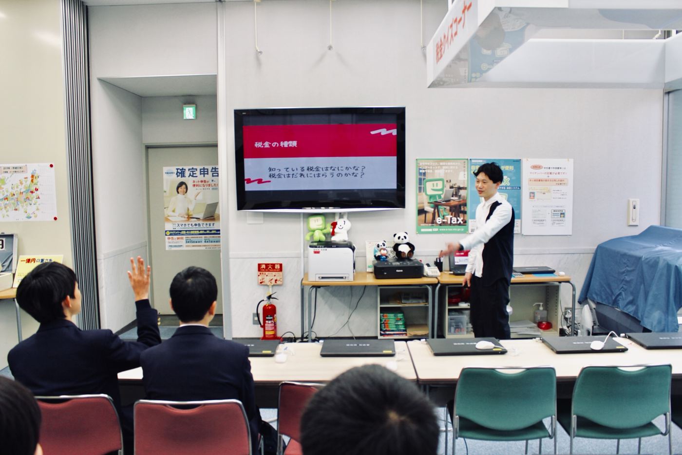 税務署の一室で税金の種類について話している